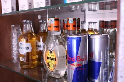 a shelf with bottles and cans of beer on it at Mkomazi Hotels and Camps in Hegoma
