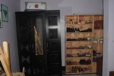 a room with a black cabinet with lots of shoes at Hakuna Matata Cozy Apartment in Karatu