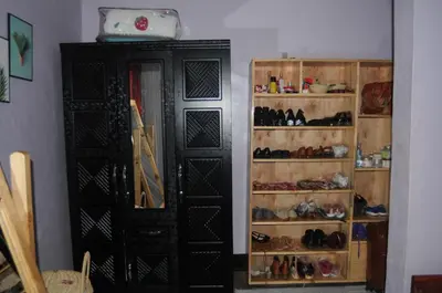 a room with a black cabinet with shoes in it at Hakuna Matata Cozy Apartment in Karatu