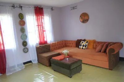 a living room with a couch and a table at Hakuna Matata Cozy Apartment in Karatu