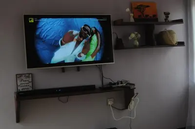 a flat screen tv hanging on a wall at Hakuna Matata Cozy Apartment in Karatu