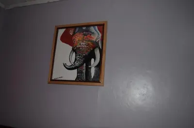 a picture of an elephant hanging on a wall at Hakuna Matata Cozy Apartment in Karatu