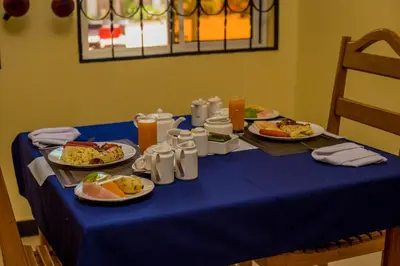 a table with plates of food on a blue table cloth at Randa Cottages Moshi in Kirua