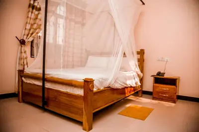 a bedroom with a canopy bed and a dresser at Randa Family House - Moshi in Himo