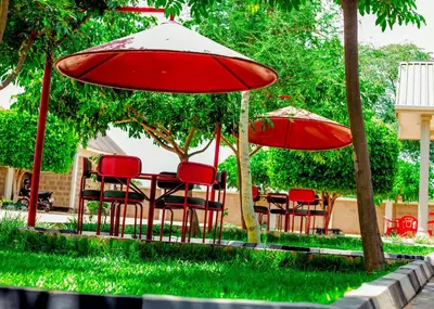 a table and chairs with red umbrellas at Randa Family House - Moshi in Himo