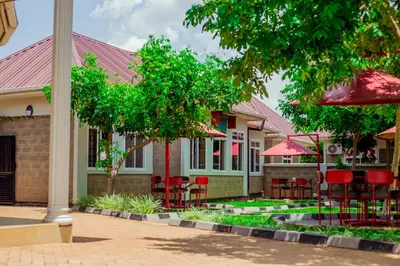 a building with red chairs and tables in front of it at Randa Family House - Moshi in Himo
