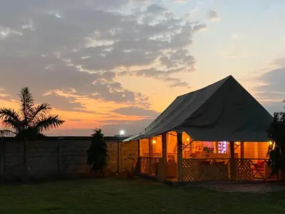 a tent with a sunset in the background at Heart of Africa Lodge in Arusha