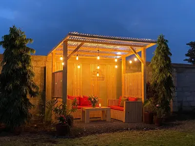 a pergola with a table and chairs in a backyard at Heart of Africa Lodge in Arusha