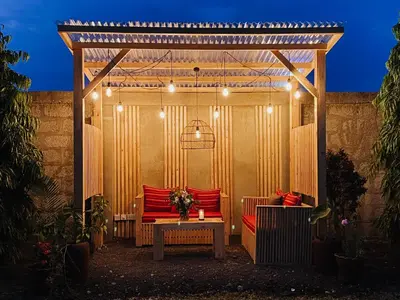 a wooden pergola with a bench and a table at Heart of Africa Lodge in Arusha