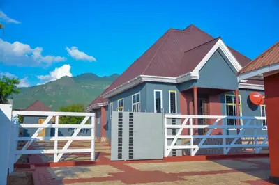 a house with a white gate and a fence at Johnsons StopPoint in Zame