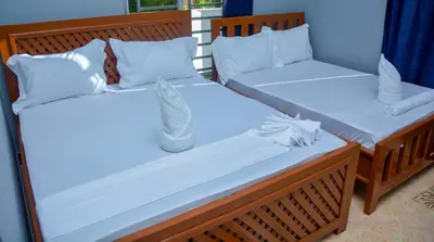 two beds in a room with white sheets and pillows at Johnsons StopPoint in Zame