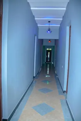 a hallway with blue walls and a long hallway with a ceiling at Johnsons StopPoint in Zame