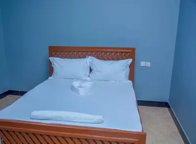 a blue room with a bed with a box on it at Johnsons StopPoint in Zame