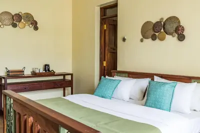a bedroom with a bed with white and blue pillows at Villa Arumeru in Arusha