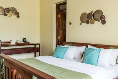 a bedroom with a bed with blue and white pillows at Villa Arumeru in Arusha