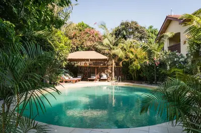 a swimming pool in the middle of a garden at Villa Arumeru in Arusha