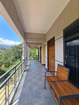 a balcony with a bench and a television at Materuni Homes in Moshi
