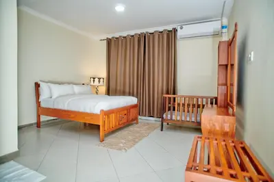 a bedroom with a bed and a crib at Hil Venture in Arusha