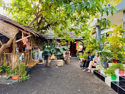 a group of people sitting in front of a building with plants at Serengeti Villa in Arusha