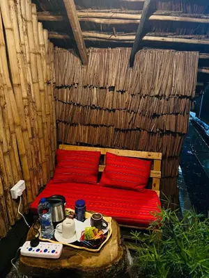 a wooden bed with red pillows and a tray of food at Serengeti Villa in Arusha