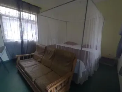 a living room with a couch and a bed at East Homestay in Boma la Ngombe
