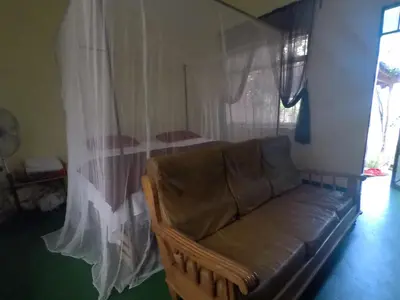 a living room with a couch and a bed at East Homestay in Boma la Ngombe