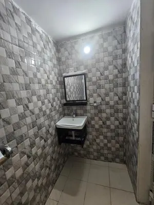 a bathroom with a sink and a tiled wall at B-MORE COMFORT STAY in Boma la Ngombe