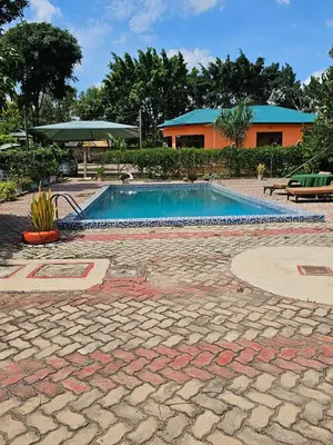a swimming pool with a house in the background at B-MORE COMFORT STAY in Boma la Ngombe