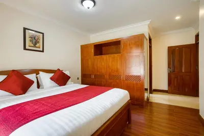 a bedroom with a large bed with a red blanket at Kibo Homes Moshi in Moshi