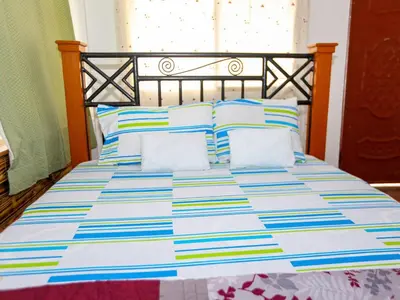 a bed with a blue and white comforter and pillows at Arusha Safari Hostel in Arusha