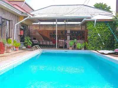 a swimming pool in front of a house at Arusha Safari Hostel in Arusha