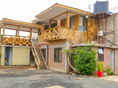 a house being built with a wooden deck on it at Arusha Safari Hostel in Arusha