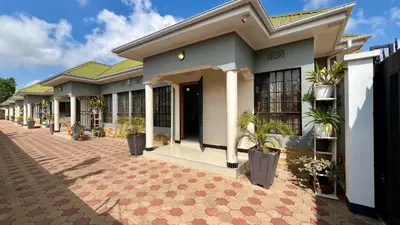 a house with a brick courtyard in front of it at Medan Apartments in Arusha