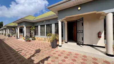 a row of houses with a gate and a courtyard at Medan Apartments in Arusha