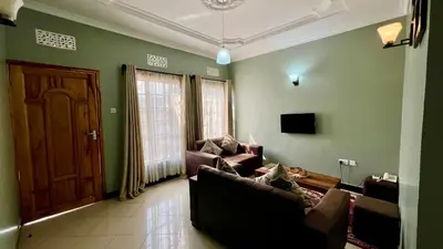 a living room with a couch and a door at Medan Apartments in Arusha
