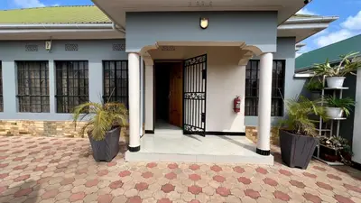 a house with a front door and potted plants at Medan Apartments in Arusha