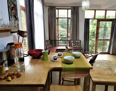 a kitchen with a wooden table with bowls on it at Holiday cottage by the river, Arusha in Arusha
