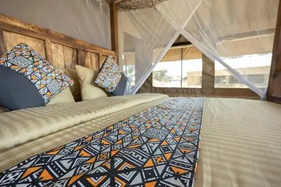 a bedroom with a bed with a comforter on it at Africa Safari South Serengeti Ndutu Ngorongoro in Sinoni