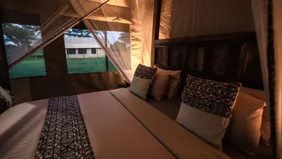 a bedroom with a bed with pillows and a window at Africa Safari South Serengeti Ndutu Ngorongoro in Sinoni
