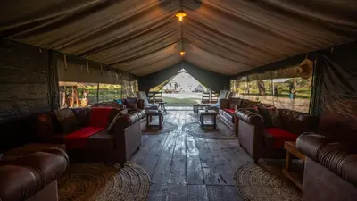 a living room with couches and tables in a tent at Africa Safari South Serengeti Ndutu Ngorongoro in Sinoni