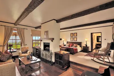 a large living room with a bed and a fireplace at The Manor at Ngorongoro in Karatu