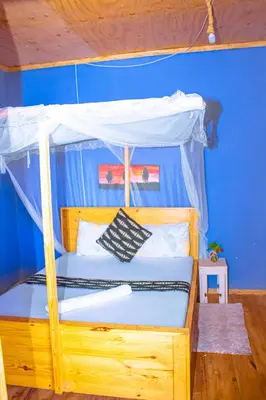 a bedroom with a wooden bed with a canopy at Arusha Jua Eco Home- on coffee farm in Arusha
