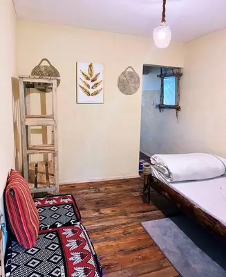 a room with two beds and a shelf in it at Arusha Jua Eco Home- on coffee farm in Arusha