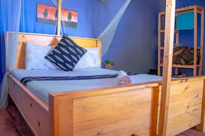 a bedroom with a wooden bed with pillows on it at Arusha Jua Eco Home- on coffee farm in Arusha
