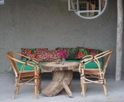 a wooden table with two chairs and a couch at Africa Amini Homes - Africa Amini Life in Nkoaranga