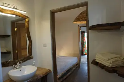 a bathroom with a sink and a mirror and a bed at Africa Amini Homes - Africa Amini Life in Nkoaranga