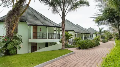 a row of houses with palm trees and a sidewalk at Forest Hill Hotel in Arusha
