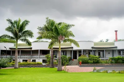 a building with palm trees in front of it at Forest Hill Hotel in Arusha
