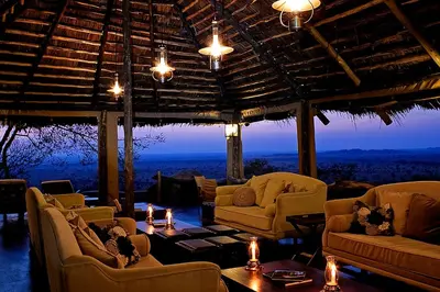a living room with couches and tables and a view at Serengeti Pioneer Camp in Mugumu