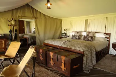 a bedroom with a bed with a trunk in it at Serengeti Pioneer Camp in Mugumu